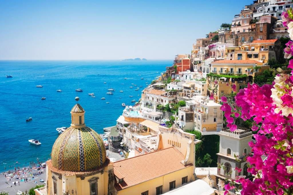 Scenic view of Positano's colorful cliffside houses cascading to the sea at sunset on the Amalfi Coast.